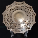 REGIA PRATA 90. Fruteira de pé alto confeccionada em metal espessurado à prata, formato decagonal com centro ligeiramente côncavo, ricamente lavrado e vazado com faixas de motivo vegetalista, assnetada sobre base elevada. Medidas: Alt.: 8 x Diam.: 27,5 cm.