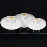 Porcelana Real, Mauá - SP(Fundada em 1943 por Fritz Erwin Schmidt). Três(03) travessas ovais em porcelana nacional da década de 1960, esmaltagem vítrea na cor branca, decoração aplicada por estampagem policromada, com motivos florais estilizados compostos por flores radiais em tons de rosa e amarelo, acompanhadas por folhas em grisaille, realçados com filete dourado aplicado na borda. Marca da manufatura no verso. Medidas: Comp.: x Larg.:  ;   Comp.: x Larg.:  ;   Comp.: x Larg.: