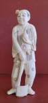 Okimono (Japão, século XIX) em marfim representando lenhador Med.: 15,5cm, assinada.