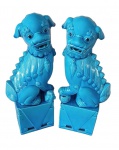 Par de figuras chinesas em porcelana azul conhecido como Cães Fó. Estas estátuas de leões guardiões tradicionalmente ficavam em frente aos palácios imperiais chineses, túmulos imperiais, edifícios administrativos, templos e residências de funcionários e das classes ricas desde a Dinastia Han (206 a.C.  220 d.C.).  Acreditava-se que eles possuíam poderes protetores. Os cães de Fó são representados em pares: o macho apoiando a pata em uma bola decorada que, em um contexto imperial, representa a supremacia mundial e a fêmea segurando um filhote brincalhão, representando o cuidado.