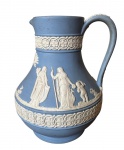 Wedgwood , Pichet em Jasper azul e branco com decoração de vestais em estilo neoclàssico, marcado na base em baixo relevo Wedgwood, Peça reproduzida no Livro Antiguidades Europeiias de André Guarisse . Em 1738 começaram as escavacões de Pompéia e Herculano próximo de Nápoles na Itália criando a partir dessa época na Europa um novo interesse ao estilo neoclássico. Em 1759 Josiah Wedgwood fundou uma manufatura de porcelana inspirada em motivos da antiguidade clássica, tornando sua empresa consagrada mundialmente. As peças eram realizadas com um tipo de material ao qual foi dado no nome Jasper.