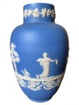 Wedgwood , Vaso em Jasper azul escuro e branco com decoração de vestais em estilo neoclàssico, marcado na base em baixo relevo Wedgwood, pequeno bicado na base  . Em 1738 começaram as escavacões de Pompéia e Herculano próximo de Nápoles na Itália criando a partir dessa época na Europa um novo interesse ao estilo neoclássico. Em 1759 Josiah Wedgwood fundou uma manufatura de porcelana inspirada em motivos da antiguidade clássica, tornando sua empresa consagrada mundialmente. As peças eram realizadas com um tipo de material ao qual foi dado no nome Jasper