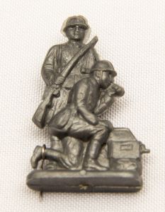 Militaria, Alemanha II Guerra. Proveniente de importante coleção adquirida em Ciney - Bélgica (Feira gigantesca de Militaria). O partido nazista promoveu uma grande arrecadação de fundos antes e durante a guerra com a venda de grande variedade de itens colecionáveis, pins, pendentes, tinnies, badges etc. Todos colecionáveis para incentivar novas compras. Como referência para estudo e identificação aconselhamos o catálogo Donation Badges, Pins & Pendants of the Third Reich de Joseph Cassidy & Christopher Alexander. Oportunidade para colecionador avançado. *Item não promove ou glorifica violência ou intolerância racial. Está à venda apenas para fins de preservação da memória histórica. A Organização do leilão não faz apologia a quaisquer movimentos políticos ou ideológicos, e repudia qualquer ideologia de cunho racista. Da série Wehrmacht Toys. Pág. 62-63. DRK 40-11. 40x25 mm. Fone de campo.