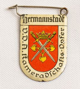 Militaria, Alemanha II Guerra. Proveniente de importante coleção adquirida em Ciney - Bélgica (Feira gigantesca de Militaria). O partido nazista promoveu uma grande arrecadação de fundos antes e durante a guerra com a venda de grande variedade de itens colecionáveis, pins, pendentes, tinnies, badges etc. Todos colecionáveis para incentivar novas compras. Como referência para estudo e identificação aconselhamos o catálogo Donation Badges, Pins & Pendants of the Third Reich de Joseph Cassidy & Christopher Alexander. Oportunidade para colecionador avançado. *Item não promove ou glorifica violência ou intolerância racial. Está à venda apenas para fins de preservação da memória histórica. A Organização do leilão não faz apologia a quaisquer movimentos políticos ou ideológicos, e repudia qualquer ideologia de cunho racista. 1934 - Brasão de cidade fora da Alemanha contendo um significativo número de alemães. Pág. 225 a 228. 33x25 mm. Hermannstadt. Rara (Sibiu-Transilvânia).