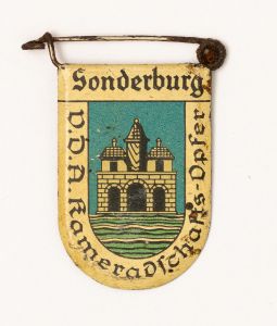 Militaria, Alemanha II Guerra. Proveniente de importante coleção adquirida em Ciney - Bélgica (Feira gigantesca de Militaria). O partido nazista promoveu uma grande arrecadação de fundos antes e durante a guerra com a venda de grande variedade de itens colecionáveis, pins, pendentes, tinnies, badges etc. Todos colecionáveis para incentivar novas compras. Como referência para estudo e identificação aconselhamos o catálogo Donation Badges, Pins & Pendants of the Third Reich de Joseph Cassidy & Christopher Alexander. Oportunidade para colecionador avançado. *Item não promove ou glorifica violência ou intolerância racial. Está à venda apenas para fins de preservação da memória histórica. A Organização do leilão não faz apologia a quaisquer movimentos políticos ou ideológicos, e repudia qualquer ideologia de cunho racista. 1936. Brasão de cidade fora da Alemanha contendo significativo número de alemães. Pág. 225 a 228. 33x25 mm. Sonderburg. Rara (Dinamarca).