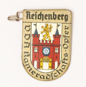 Militaria, Alemanha II Guerra. Proveniente de importante coleção adquirida em Ciney - Bélgica (Feira gigantesca de Militaria). O partido nazista promoveu uma grande arrecadação de fundos antes e durante a guerra com a venda de grande variedade de itens colecionáveis, pins, pendentes, tinnies, badges etc. Todos colecionáveis para incentivar novas compras. Como referência para estudo e identificação aconselhamos o catálogo Donation Badges, Pins & Pendants of the Third Reich de Joseph Cassidy & Christopher Alexander. Oportunidade para colecionador avançado. *Item não promove ou glorifica violência ou intolerância racial. Está à venda apenas para fins de preservação da memória histórica. A Organização do leilão não faz apologia a quaisquer movimentos políticos ou ideológicos, e repudia qualquer ideologia de cunho racista. 1934. Brasão de cidade fora da Alemanha contendo significativo número de alemães. Pág. 225 a 228. 33x25 mm. Reichenberg. Raríssimo.