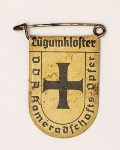 Militaria, Alemanha II Guerra. Proveniente de importante coleção adquirida em Ciney - Bélgica (Feira gigantesca de Militaria). O partido nazista promoveu uma grande arrecadação de fundos antes e durante a guerra com a venda de grande variedade de itens colecionáveis, pins, pendentes, tinnies, badges etc. Todos colecionáveis para incentivar novas compras. Como referência para estudo e identificação aconselhamos o catálogo Donation Badges, Pins & Pendants of the Third Reich de Joseph Cassidy & Christopher Alexander. Oportunidade para colecionador avançado. *Item não promove ou glorifica violência ou intolerância racial. Está à venda apenas para fins de preservação da memória histórica. A Organização do leilão não faz apologia a quaisquer movimentos políticos ou ideológicos, e repudia qualquer ideologia de cunho racista. 1934. Brasão de cidade fora da Alemanha contendo significativo número de alemães. Pág. 225 a 228. 33x25 mm. Lugumkloster.