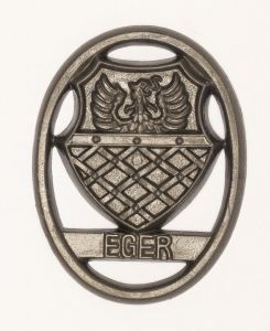 Militaria, Alemanha II Guerra. Proveniente de importante coleção adquirida em Ciney - Bélgica (Feira gigantesca de Militaria). O partido nazista promoveu uma grande arrecadação de fundos antes e durante a guerra com a venda de grande variedade de itens colecionáveis, pins, pendentes, tinnies, badges etc. Todos colecionáveis para incentivar novas compras. Como referência para estudo e identificação aconselhamos o catálogo Donation Badges, Pins & Pendants of the Third Reich de Joseph Cassidy & Christopher Alexander. Oportunidade para colecionador avançado. *Item não promove ou glorifica violência ou intolerância racial. Está à venda apenas para fins de preservação da memória histórica. A Organização do leilão não faz apologia a quaisquer movimentos políticos ou ideológicos, e repudia qualquer ideologia de cunho racista.  1941. Brasão de cidade ocupada ou fronteira alemã. Pág. 237 a 238. 38x29 mm. Eger.