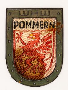 Militaria, Alemanha II Guerra. Proveniente de importante coleção adquirida na Bélgica - Feira de Militaria de Ciney. O partido nazista promoveu uma grande campanha de arrecadação de fundos antes e durante a guerra, com a venda de itens colecionáveis, pins, pendentes, tinnies, badges etc. Sempre colecionáveis voltada a novas compras. Oportunidade para colecionador avançado. **Item não promove ou glorifica violência ou intolerância racial. Está à venda apenas para fins de preservação da memória histórica. A Organização do leilão não faz apologia a quaisquer movimentos políticos ou ideológicos, e repudia qualquer ideologia de cunho racista. Campanha de Inverno WHW em tecido e metal. Pommern - no estado. 31x43 mm.