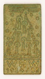 Militaria, Alemanha II Guerra. Proveniente de importante coleção adquirida na Bélgica - Feira de Militaria de Ciney. O partido nazista promoveu uma grande campanha de arrecadação de fundos antes e durante a guerra, com a venda de itens colecionáveis, pins, pendentes, tinnies, badges etc. Sempre colecionáveis voltada a novas compras. Oportunidade para colecionador avançado. **Item não promove ou glorifica violência ou intolerância racial. Está à venda apenas para fins de preservação da memória histórica. A Organização do leilão não faz apologia a quaisquer movimentos políticos ou ideológicos, e repudia qualquer ideologia de cunho racista. Campanha de Inverno em madeira. WHW 1934/35. 51x26 mm.