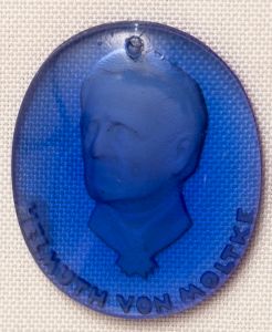 Militaria, Alemanha II Guerra. Proveniente de importante coleção adquirida na Bélgica - Feira de Militaria de Ciney. O partido nazista promoveu uma grande campanha de arrecadação de fundos antes e durante a guerra, com a venda de itens colecionáveis, pins, pendentes, tinnies, badges etc. Sempre colecionáveis voltada a novas compras. Oportunidade para colecionador avançado. **Item não promove ou glorifica violência ou intolerância racial. Está à venda apenas para fins de preservação da memória histórica. A Organização do leilão não faz apologia a quaisquer movimentos políticos ou ideológicos, e repudia qualquer ideologia de cunho racista. WHW - Campanha de Inverno em vidro. Helmuth Von Moltke. General-Marechal Prussiano.