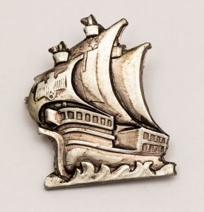 Militaria, Alemanha II Guerra. Proveniente de importante coleção adquirida na Bélgica - Feira de Militaria de Ciney. O partido nazista promoveu uma grande campanha de arrecadação de fundos antes e durante a guerra, com a venda de itens colecionáveis, pins, pendentes, tinnies, badges etc. Sempre colecionáveis voltada a novas compras. Oportunidade para colecionador avançado. **Item não promove ou glorifica violência ou intolerância racial. Está à venda apenas para fins de preservação da memória histórica. A Organização do leilão não faz apologia a quaisquer movimentos políticos ou ideológicos, e repudia qualquer ideologia de cunho racista. Nau Alemã com marca do fabricante no verso, usada em treinamento de aspirantes a oficiais. 35x27 mm. TBM Navio Albergue da Juventude Hitlerista.