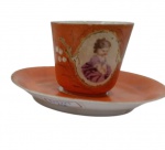 ROYAL VIENNA (Áustria), Xícara para café de coleção com seu respectivo pires confeccionada em porcelana austríaca esmaltada na tonalidade  laranja  , decorado  com figura de menina em policromia e guirlanda floral, filetes e realces em ouro, desgaste do tempo , medindo 6 x5cm.