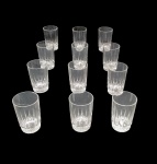 CONJUNTO DE  12  COPOS DE VIDRO NADIR FIGUEREDO TRANSLUCIDO LAPIDADO NA BASE , UM DOS COPOS TEM UM BICADO COMO MOSTRADO NA FOTO, MEDINDON10 X 7 CM ( 1 COM PEQUENO BICADO0)