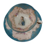 VIEUX PARIS - Século XIX - xicara em formato de taça  com pires em porcelana Vieux  Paris  decorada com guirlandas de flores e rosáceas e figura de Napoleão Bonaparte no fundo.Medindo 4,5 x 7 cm