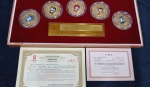 Belissimo conjunto comemorativo oficial dos Jogos Olimpicos de Pequim 2008 composto por 5 medalhões dourados  em relevo e aplicações coloridas esmaltadas  acondicionadas em capsulas acrilicas ,  representando  os mascotes dos jogos, estojo original revestido em veludo vermelho, placa  e certificado de autenticidade ,  numerado , edicão limitada. PEÇA DE COLECIONADOR.