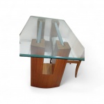 Mesa de jantar de estilo contemporâneo, composta por tampo retangular em vidro temperado, com espessura aproximada de 10 a 12 mm, bordas polidas e cantos levemente arredondados. Base estruturada em madeira industrializada (MDF/MDP) com acabamento amadeirado, apresentando design moderno com recorte central decorativo e colunas tubulares em metal (metal necessita pintura prateada) internas de sustentação, conferindo estabilidade e apelo estético ao conjunto. Peça de linhas limpas e visual elegante  4 lugares ,pequeno lascado no vidro , medindo 1,80 x    90 x 82 de altura ( veja imagens extras ) retirada com agendamento na Barra da Tijuca .