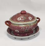 China / Red Wan Shou, Jingdezhen, Famille Rose. Terrina oval com tampa e presentoir. Porcelana de pasta dura. Rica policromia em vermelho/rosa, pintada à mão overglaze. Clássico design Wan Shou Wu Jiang. A expressão Wan Shou Wu Jiang, usada desde 1100 A.C., significa Longevidade sem Limite, Existência Eterna. Marca no fundo. Altura 27cm x Comprimento 37 x Largura 27cm. Presentoir - 36 x 30 cm.  Excelente estado de conservação.