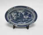 China / BLUE CANTON. Travessa Macau ou Pagode em porcelana Jingdezhen de pasta dura. Esmalte azul e branco underglaze. Clássico design de Wu-tong Chinese parasol tree, paisagem de montanha, rio, pontes e pagodes. 25 x 18 cm. Marca no verso. Excelente estado de conservação