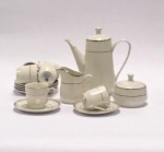 China / Séc. XX  Conjunto de café para 6 pessoas. Porcelana de pasta dura. Cor marfim com filete de ouro. Marca no verso. Bule de café  Altura 18 x 18 cm; Açucareiro Altura 8 x 9,5 cm; Leiteira Altura 9 x 10 cm; 6 Xicara de café com pires - Altura 6 cm, pires Diâmetro 12 cm. Excelente estado de conservação.