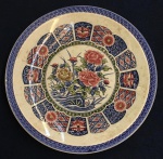 Grande medalhão em porcelana japonesa ao gosto Imari manufaturado MZ China. Decorado com flores, folhas e rochas Típicas tons de Imari  azuis, rouge de fer e verdes. Borda com tradicionais desenhos Imari.  Apresenta marcas de uso.Diâmetro 42
