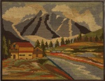 Clássico quadro de tapeçaria bordada , moldura em madeira, cenário alpino à beira rio. Mede 51 x 65cm.