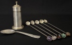 Lote contendo diversos objetos em metal espessurado a prata, sendo um paliteiro com tampa flexível, uma inusitada colher para criança e cinco mexedores de bebidas. Medida do maior 18ccm.