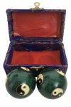Conjunto composto por bolas chinesas de meditação Baoding em metal esmaltado na cor verde, decoradas com o símbolo do Yin-Yang em tons de marfim e preto. Acompanha caixa original revestida em tecido azul bordado com interior em cetim vermelho.As bolas de Baoding são tradicionalmente utilizadas para exercícios de relaxamento, equilíbrio de energia e concentração. Origem: China. Década de 1980.Mede 10,5cm x 6cm.