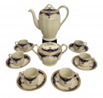 ENGLAND - Serviço de café em porcelana inglesa Grindley England, padrão Cream Petal.Decoração clássica com frisos e arabescos dourados sobre fundo azul-cobalto.Conjunto composto por cafeteira, açucareiro e seis xícaras com pires.Elegante exemplar da produção inglesa do início do século XX.