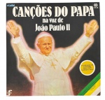 JOÃO PAULO II  CANÇÕES DO PAPA (LP, 1980, CID/Crystal) - Raro vinil brasileiro intitulado Canções do Papa na voz de João Paulo II, lançado pela gravadora CID / Crystal em comemoração à primeira visita do Papa João Paulo II ao Brasil, em 1980. Produção da série Sacresong, acompanhava encarte e pôster original da revista Manchete com retrato de Sua Santidade. O repertório reúne canções religiosas e folclóricas polonesas, interpretadas pelo próprio Papa, entre elas Fanfarra para os Papas, Oh Maria, Rogai por Nós e Nossa Senhora Morena.Peça de forte valor histórico e devocional, símbolo da visita papal ao Brasil e da popularidade de João Paulo II entre os fiéis.  altamente colecionável entre religiosos e amantes de memorabilia católica.