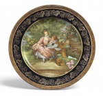 LIMOGES FRANÇA - Imponente medalhão em pasta de porcelana francesa LIMOGES FRAGONARD ricamente esmaltado e dourado, com cena galante em estilo rococó inspirada em Jean-Honoré Fragonard. Aba em azul cobalto com exuberante decoração floral em ouro. Marca no verso Fragonard  France, produção de Limoges, século XIX. Peça de caráter decorativo, refinamento clássico e excelente efeito ornamental. Assinada. Mede 26 cm diâmetro.