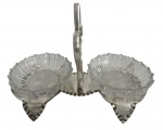 Petisqueira dupla de mesa em metal espessurado com marcas, base recortada com alça central, acompanhada de dois recipientes em cristal lapidado. Peça de mesa elegante, de provável produção europeia, início do século XX. Apresenta marcas de contraste na base. Bom estado geral, com marcas do tempo compatíveis com a idade. Mede 23 x 16 cm.