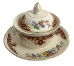 INGLATERRA - Açucareiro com tampa e pires em faiança inglesa, marca Woods  Ivory Ware, Inglaterra com decoração floral policromada e guirlanda em tom vinho, detalhes dourados na borda. Base marcada, início séc. XX. Estado de conservação compatível com a idade, com craquelês e leves sinais de uso. Mede 15 cm diâmetro.