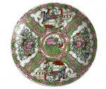 Prato em porcelana oriental ricamente decorado, com cenas figurativas e florais distribuídas em reservas, em tons de verde, rosa, vermelho e dourado. Centro com motivo simbólico e borda trabalhada em estilo clássico. Reverso com marca oriental em vermelho e preto. Peça de forte caráter decorativo, típica da produção chinesa para exportação. Bom estado geral, com leves sinais do tempo. Mede 19 cm diâmetro.