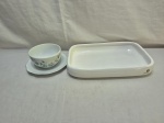 Lote de travessa retangular e molheira redonda em porcelana. Medindo a travessa 32cm x 21cm x 5,5cm de altura.