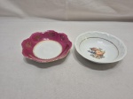 Lote de 2 bowls em porcelana, sendo um vinho com ouro e um com frutas ao fundo e friso ouro. Medindo o maior 14cm x 4cm de altura.