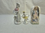 Lote de 3 enfeites em porcelana, sendo um anjo e 2 meninas. Medindo o maior 17cm de altura.