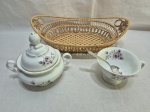 Lote de cesta, pãozeira em ratam trançado, açucareiro e xícara sem pires em porcelana, colher em prata 90. Medindo a cesta 32cm x 22cm x 9,5cm de altura.