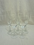 Lote de 5 taças em demicristal incolor com pé canelado. Sendo 3 flute e 2 de água. Medindo 5cm x 25,5cm de altura; 8cm x 20cm de altura.