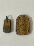 Conjunto com dois pingentes confeccionados em pedra natural Olho de Tigre, de origem importada, já que não existem minas dessa pedra no Brasil.Uma das peças apresenta uma escultura primorosa representando o Buda, com excelente nível de detalhe e acabamento, tornando o conjunto ainda mais especial. Itens de grande valor estético e simbólico, ideais para coleção, uso pessoal ou apreciação espiritual.Qualquer dúvida entrar em contato pelo WhatsApp: 11932480666.OBS: A sua participação em nosso leilão ajuda em causas animais.