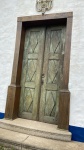 PORTA DA CAPELA DA FAZENDA SÃO LOURENÇO (PORTAS DUPLAS E BATENTE) EM MADEIRA PATINADA REMATADA POR ALMOFADAS EM DOCE DE LEITE. FERRAGEM ORIGINAL COM FECHADURA E CHAVE FUNCIONAIS. BRASIL, SEC. XVIII.
