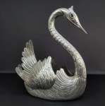 MANOEL ALCINO  FAUSTOSO, ELEGANTE E DESEJÁVEL  FLOREIRO/CENTRO DE MESA  EM PRATA DE LEI COM FEITIO ZOOMORFICO REPRESENTANDO  CISNE. ASAS ARTICULADAS, CORPO ARTISTICAMENTE CINZELADO. CONTRASTE ÁGUIA DA CIDADE DO PORTO E MARCAS DO PRATEIRO MANOEL ALCINO, UM DOS MAIS IMPORTANTES PRATEIROS PORTUGUESES AA PRIMEIRA METADE DO SEC. XX . A MARCA FOI REGISTRADA  EM 1935 ACOMPANHADA DO  CONSTRASTE AGUIA TEOR 833.  PORTUGAL, INICIO DO SEC. XX. 45 CM DE ALTURA. 2180 G