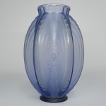 SABINO    PIROGUE (MODELO 7024)  LINDO FLOREIRO EM VIDRO ASTÍSTICO AZUL MODELO PIROGUE DE SABINO. ESTILO E ÉPOCA ART DECO DECADA DE 1930. FORMATO OBLONGO E BULBOSO É DECORADO COM RELEVO DE 24 CANOAS DISPOSTAS EM UM PADRÃO DE QUINCUNCE EM PERFEITA SIMETRIA. ESTE PADRÃO TAMBÉM FOI APLICADO EM LUSTRES E ARANDELAS PRODUZIDOS POR ESTE ESPETACULAR MESTRE VIDREIO. A OPALESCÊNCIA DESTE EXEMPLAR, SUTILMENTE AVELUDADA COM NUANCES AZULADAS, É TÍPICA DAS OBRAS MAIS REFINADAS DE MARIUS SABINO. ESTE VASO OSTENTA O NÚMERO 7024 NO CATÁLOGO DA SABINO DE 1930. PRIMEIRA FABRICAÇÃO: PROVAVELMENTE EM 1928. SEU MOLDE FOI DESTRUÍDO E NÃO FOI REEDITADO APÓS 1945. FRANÇA, DECADA DE 1930. 29CM DE ALTURA  (TEM UM PEQUENO TRINCO  SUPERFICIAL NO TERÇO INFERIOR CONFORME FOTO   QUE ENTRETANTO NAO AFETA A ESTRUTURA  DO VASO)NOTA: Sabino Art Glass, França, séc. XIX/XXA empresa Sabino Maitre Verrier (Sabino Master Glassmaker) foi fundada em Paris em 1919 pelo siciliano Marius Ernest Sabino. Ele cresceu na França e frequentou a L'Ecole Nationale Des Arts Decoratifs e a Beaux Arts de Paris. Sua produção anterior foram lustres de metal, lâmpadas embutidas e acessórios arquitetônicos em vidro moldado, e depois da Primeira Guerra Mundial ele diversificou em objetos decorativos no estilo Art Deco ou Art Nouveau, que ele havia projetado.Foi em 1925 que Sabino criou pela primeira vez o vidro opalescente semitransparente em tons de azul pelo qual a empresa é mais conhecida e expandiu seus negócios para fazer estatuetas e estatuetas, tanto humanas quanto animais.Na década de 1930, Sabino mudou sua produção para sua fábrica em Noisy-le-Sec, nos subúrbios do sudeste de Paris, onde a produção continuou usando as mesmas técnicas e moldes.A produção limitada com o consentimento dos alemães continuou durante a Segunda Guerra Mundial e, quando a guerra terminou, Sabino transferiu as operações da empresa para seu sobrinho e filho adotivo Gripoix Sabino, onde a produção continuou usando os mesmos moldes.Marius Sabino morreu em 1961 e Gripoix Sabino continuou a produção, ainda usando as mesmas técnicas e moldes. Quase toda a produção estava sendo exportada para os Estados Unidos, e em 1978 o negócio foi vendido para Richard Choucroun, agente americano da empresa, negociando como "Sabino Crystal Company".A "Sabino Crystal Company" está sediada em Houston, Texas, e ainda vende as mesmas estátuas opalescentes semitransparentes em tons de azul e itens decorativos que foram feitos pela primeira vez no final da década de 1920.