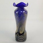 JAN ZEMAN  BELO FLOREIRO EM VIDRO ARTÍSTICO DA BOHEMIA EM AZUL COBALTO DECORADO COM AVENTURINA QUE CONFERE LINDA IRIDESCÊNCIA. COM ESTILO ART DECO TEM BORDA RECORTADA E BASE REMATADA EM ONDAS. ASSINADO SOB A BASE. INSPIRADO NA PRODUÇÃO DE LOETZ TRAZ OS ELEMENTOS DA TRADIÇÃO BOHEMIA COM A FORMA PRÓPRIA RECORRENTE NO TRABALHO DE JAN ZEMAN. MEADOS DO SEC. XX. 29 CM DE ALTURA.