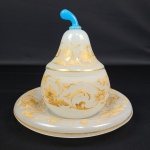 MAGNIFICA COMPOTIER/POT A CONFITURE (PORTA GELÉIAS)  EM OPALINA BRANCA MILK GLASS COM SEU PRESENTOIR.  FEITIO DE PERA REMATADA EM OURO FORMANDO GURILANDA DE FLORES E RAMAGENS.  . ESTILO E ÉPOCA NAPOLEÃO III.. PEGA DA TAMPA NA TONALIDADE AZUL OVO DE PISCO, EMULA PEDUNCULO DO FRUTO . FRANÇA, SEGUNDA METADE DO SEC. XIX. 18 X 17 CM
