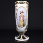 MOSER  BOHEMIA SOB O IMPERIO AUSTRO HUNGARO.  FABULOSO FLOREIRO EM OVERLAY BRANCO E TRANSLÚCIDO COM RESERVAS CONSTENDO DUAS EXUBERANTES PINTURAS FLORAIS  REPRESENTANDO A FLORA LOCAL E UMA APRESENTANDO MENINO VESTIDO COM INDUMENTARIA KROJ (TRAJE TIPICO BOHEMIO): CAMISA DE LINHO BRANCO REMATADA POR FITAS, COLETE ESCURO ADORNADO COM FLORES, CHAPÉU TAMBÉM ADORNADO E CALÇAS TIPICAS. O CROPO É REMATADO EM OURO COM TRIFOLEOS TRANLUCIDOS EMOLDURADOS EM BRANCO. PEÇA DE ALTO COLECIONISMO! DEC. 1870. 26 CM DE ALTURA