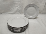 Jogo de 6 pratos rasos de sobremesa em porcelana com relevos e friso prata. Medindo 19,5cm de diâmetro.
