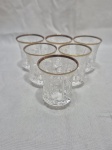Jogo de 6 copos de aperitivo em cristal ricamente lapidado com friso ouro. Medindo 5cm x 6,5cm de altura.