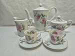 Jogo de servir café tete a tete em porcelana floral com friso ouro. Medindo o bule 15,5cm de altura, açucareiro com a alça restaurada.