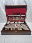 Faqueiro de 130 peças em prata 90 Radio cabo trabalhado, estojo em madeira com fundo em veludo vermelho. Faltando apenas 1 garfo, 1 faca e 1 colher de sobremesa. Medindo 52,5cm x 40cm x 13cm de altura.